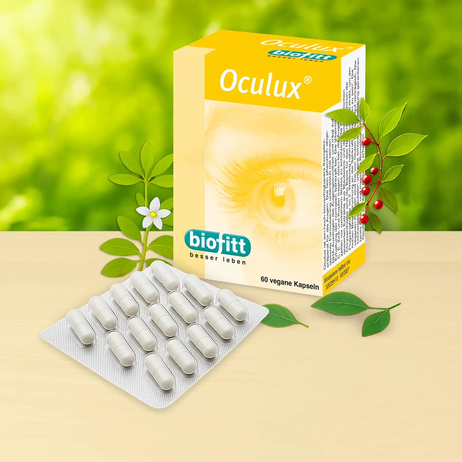 Oculux Augenkapseln von biofitt mit Faltschachtel und Blister vor grünem Pflanzenhintergrund